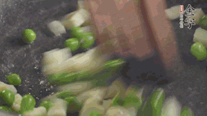 鍋中油7成熱時(shí)，入青豆、筍丁翻炒，然后加糯米飯加鹽均勻翻炒。