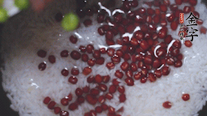 將炒好的食材和大米、紅豆一起放進(jìn)電飯鍋煮。