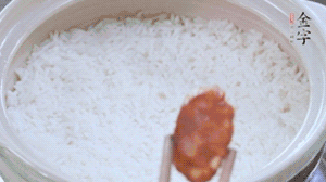 煮開(kāi)后轉(zhuǎn)小火，當(dāng)米飯出現(xiàn)小孔時(shí)，鋪上金字麻辣香腸。