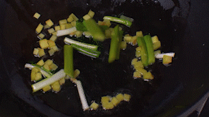 鍋中熱油，依次下姜粒、蔥段、蘆筍炒香。