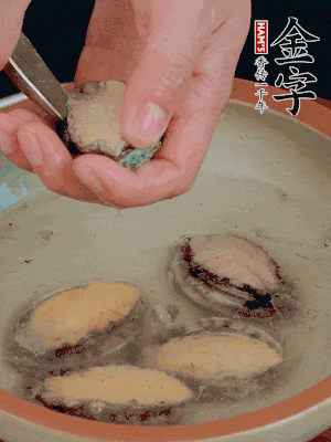 鮑魚加鹽、清水浸泡，用勺子挖出鮑魚肉。