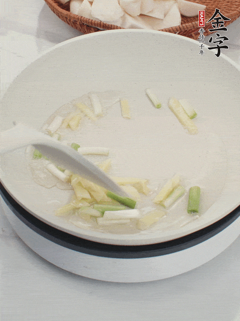 鍋中油五成熱，下蔥白、姜片爆香。