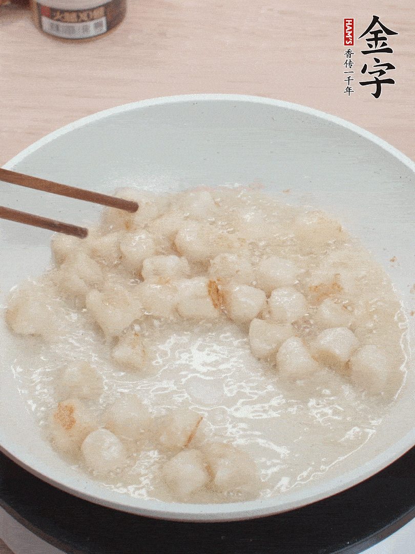 油溫4成熱，鮮貝蘸干淀粉下鍋煎，一面微黃后翻面。