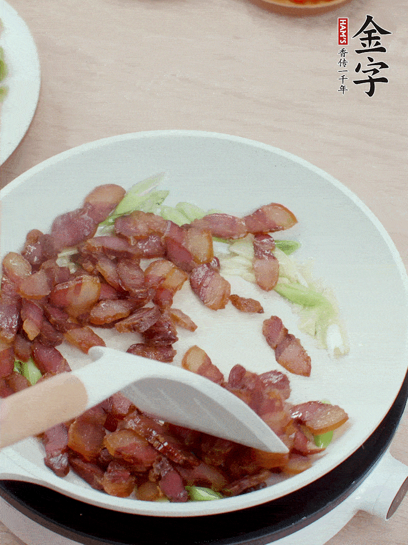 鍋中少許油，姜、蒜白爆香，下臘肉煸出油脂。