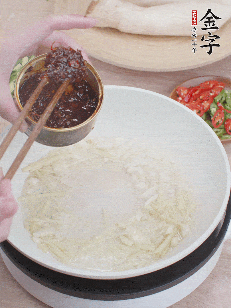 起鍋熱油，姜蒜、金字火腿干貝醬煸香。