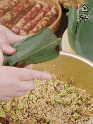 粽葉往下折，完全蓋住，兩側捏緊。