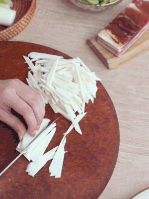 茭白切細(xì)絲，鹽水中浸泡防止氧化。