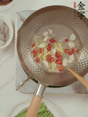 油7成熱時(shí)，下大蒜粒、姜絲、小米辣煸香。