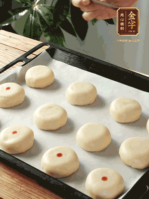 收口向下放在案板上，輕輕將月餅坯按扁，用筷子點紅點做裝飾