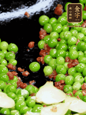 鍋內少許油，下火腿煸香，再下甜豆米、百合翻炒，少許鹽、一點水煮到收干