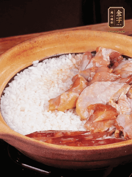 煮到椰子水微微收干轉(zhuǎn)小火，快速均勻鋪上雞肉、金字香腸