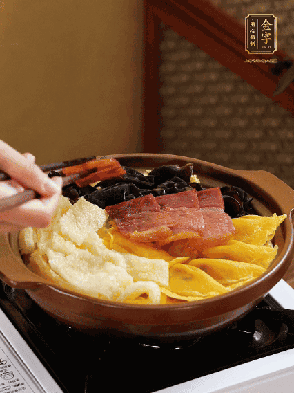 砂鍋底部鋪上娃娃菜，依次擺上肉皮、蛋餃、黑木耳、火腿