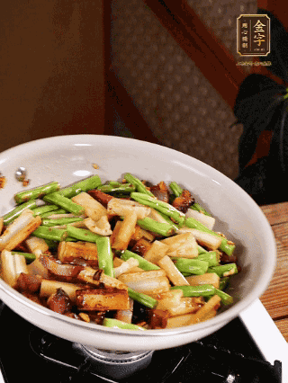 油熱下蒜末、干辣椒、醬肉煸炒出香味，依次下藕條、豆角翻炒均勻